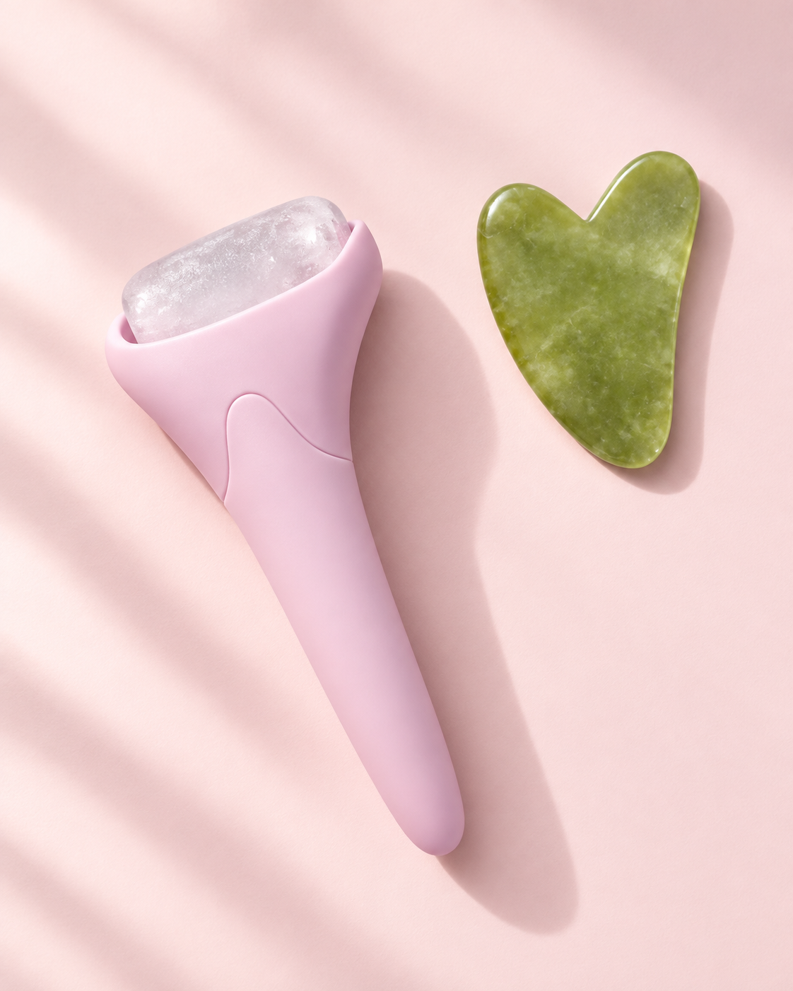 Rosa LUMA-isroller og grønn gua sha-stein blant myke pastellformer